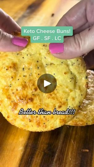 a person holding up a piece of food on top of a wooden table with text reading keto cheese buns