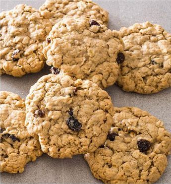 cookies with raisins and cranberries are arranged on a baking sheet, ready to be eaten