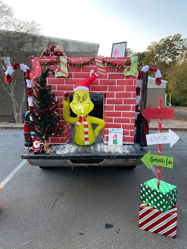 a truck is decorated with christmas decorations and signs for the holiday season, including a grinch