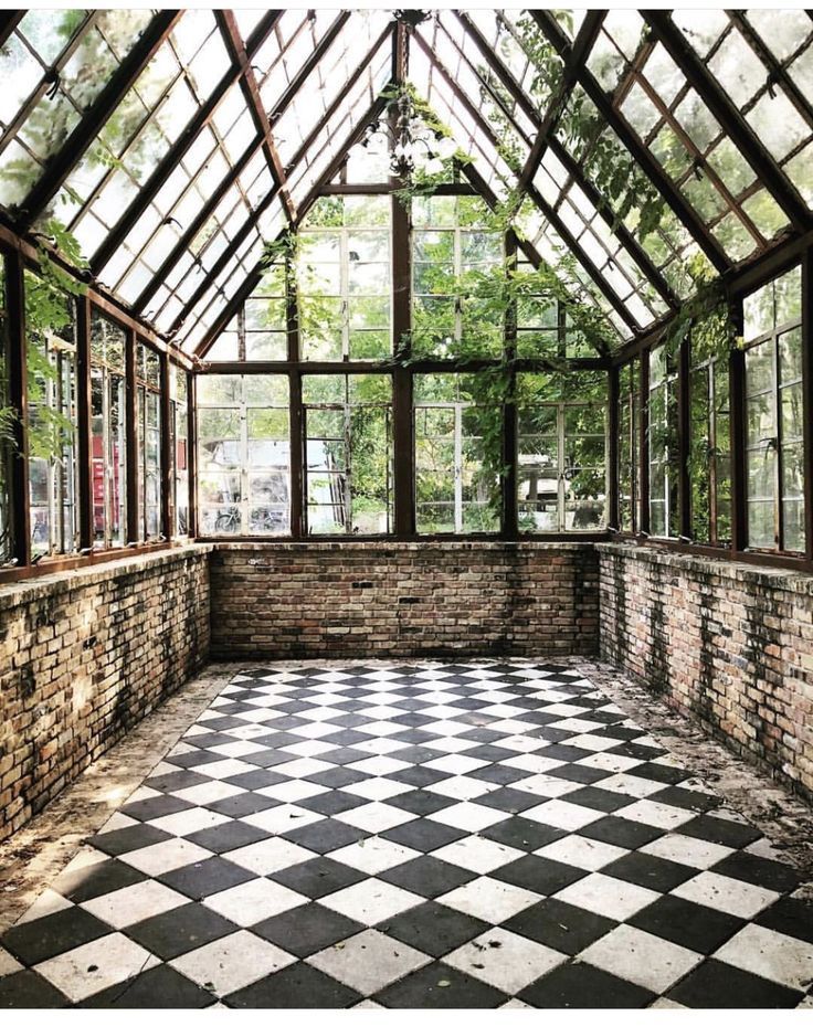 an empty room with lots of windows and black and white checkered tile flooring