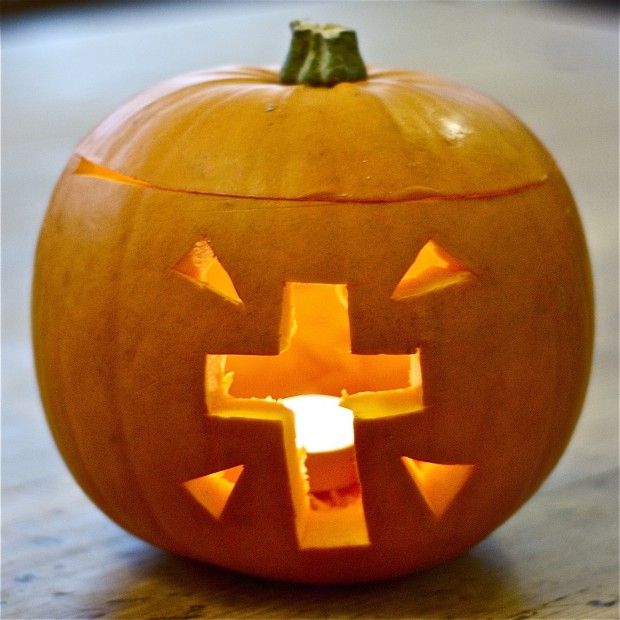 a carved pumpkin with the shape of a cross on it