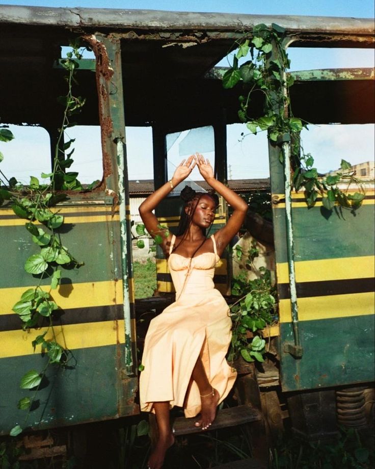 a woman in a dress sitting on the side of a train