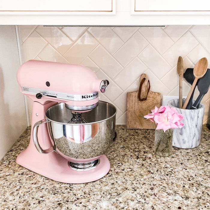 a pink mixer sitting on top of a kitchen counter