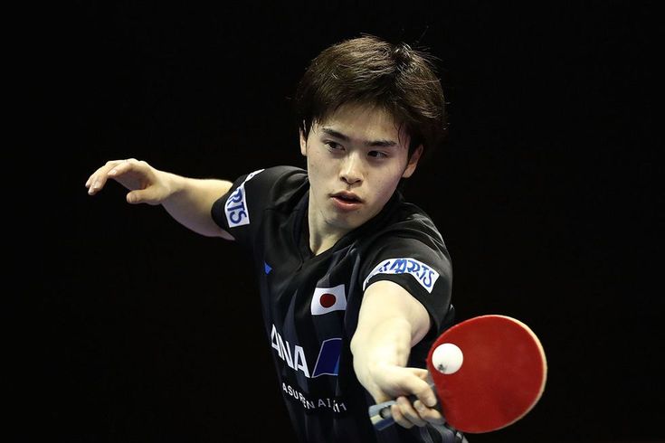 a man holding a ping pong racket in his hand and hitting the ball