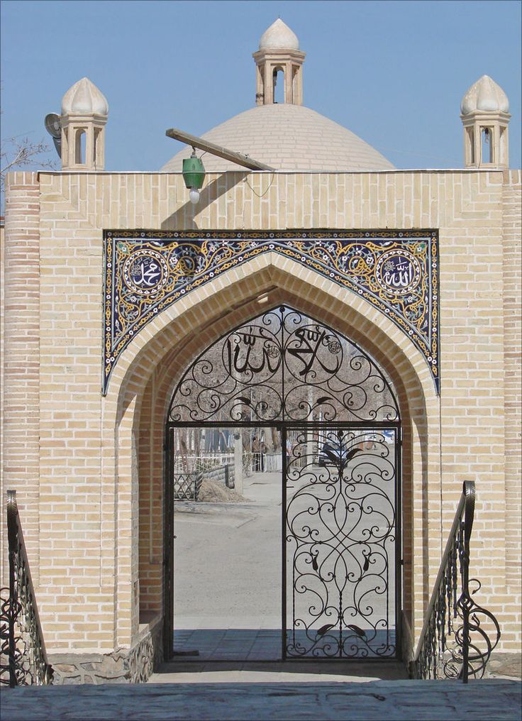 the entrance to an old brick building with wrought iron gates