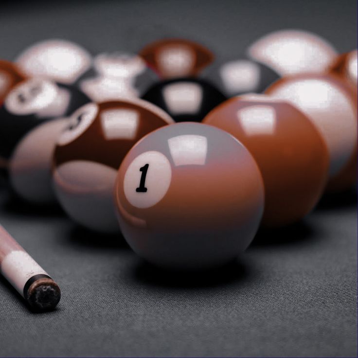 billiards balls and cues are arranged in a row on a pool table