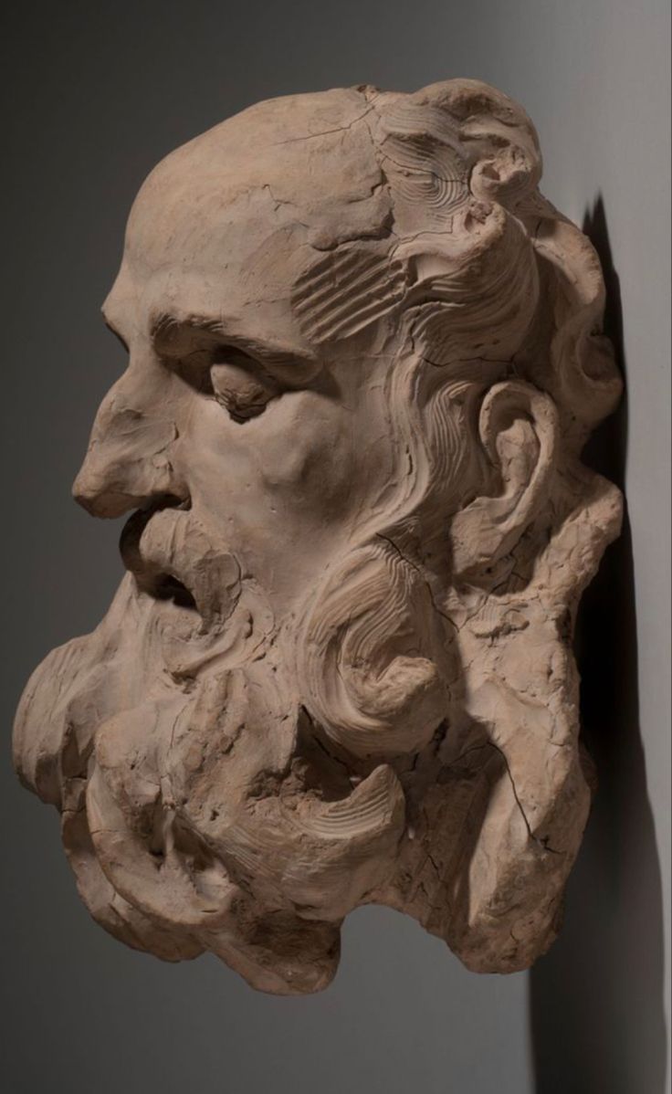 a sculpture of an old man's head is shown next to a statue of a bearded man