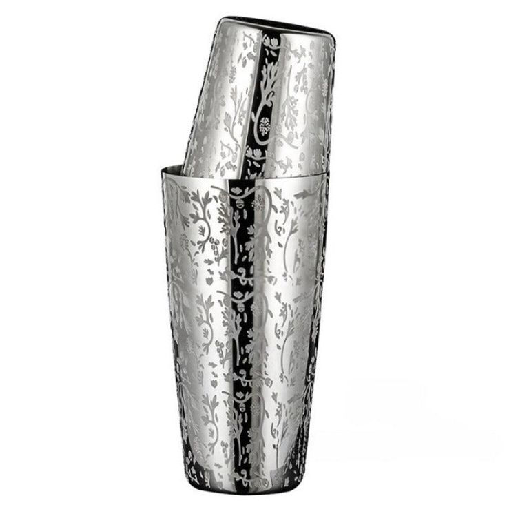 a tall silver vase sitting on top of a table