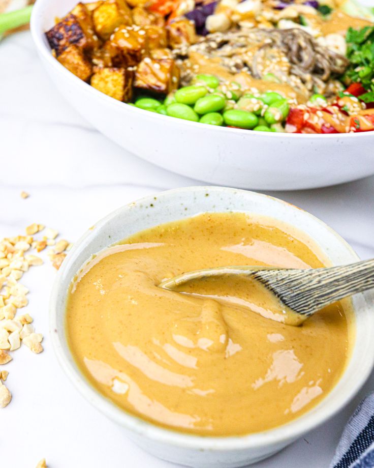 two bowls filled with different types of food and one has a spoon in the bowl