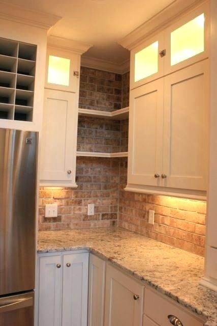 a kitchen with white cabinets and granite counter tops, along with a stainless steel refrigerator