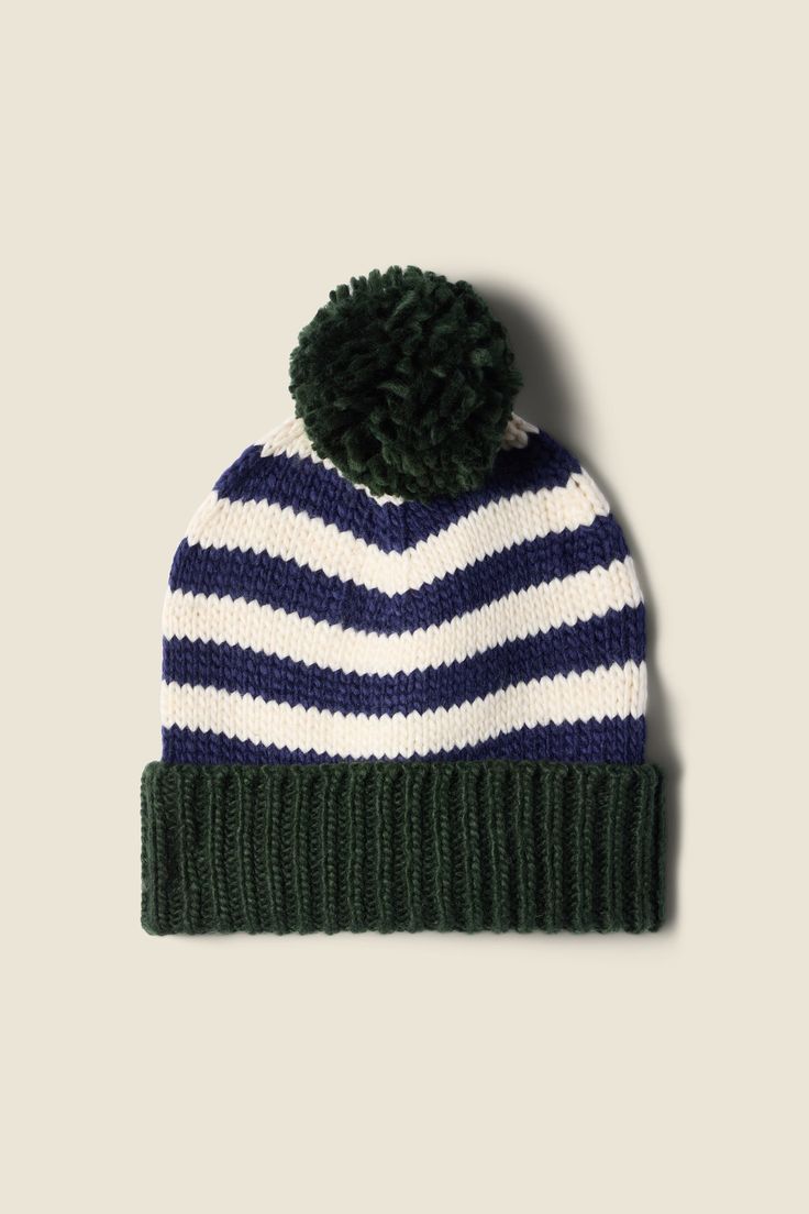 a blue and white striped hat with a green pom - pom