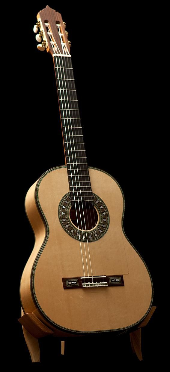 an acoustic guitar sitting on top of a wooden stand