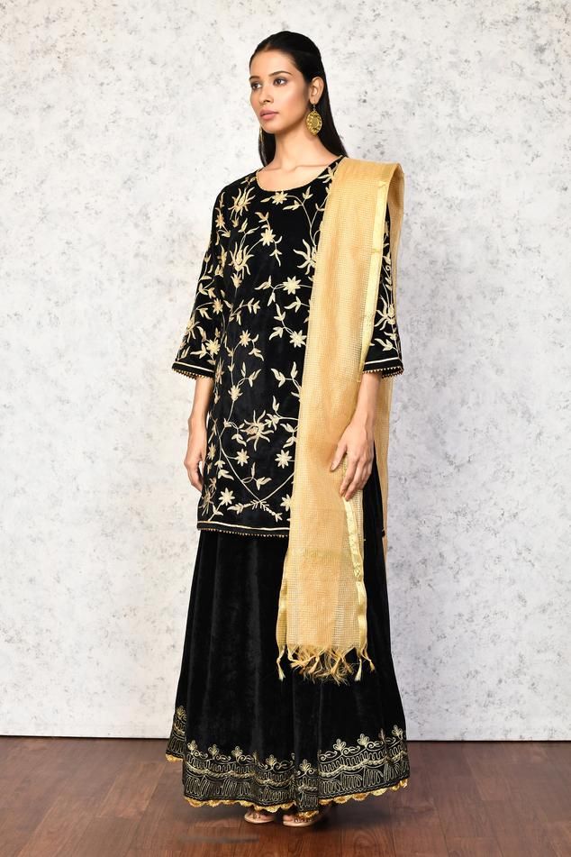 Black kurta with contrast floral embroidery. Paired with a lehenga, highlighted with floral embroidered hem. Comes along with a dupatta.
Components: 3
Pattern: Embroidery
Type Of Work: Floral
Neckline: Round Neck
Sleeve Type: Three Quarter Sleeves
Fabric: Kurta and Lehenga: Velvet, Dupatta: Chanderi, Lining: Shantoon
Color: Black
Other Details: 
Length:
Kurta: 36 inches
Lehenga: 40 inches
Occasion: Mehendi and Haldi - Aza Fashions Festive Black Floral Embroidered Palazzo Set, Anarkali Style Black Palazzo Set With Floral Embroidery, Black Anarkali Palazzo Set With Floral Embroidery, Festive Black Palazzo Set With Floral Embroidery, Elegant Black Sharara With Floral Embroidery, Black Chanderi Kurta With Embroidered Border, Fitted Palazzo Set With Embroidered Border, Eid Black Sharara With Floral Embroidery, Black Palazzo Set With Floral Embroidery For Eid