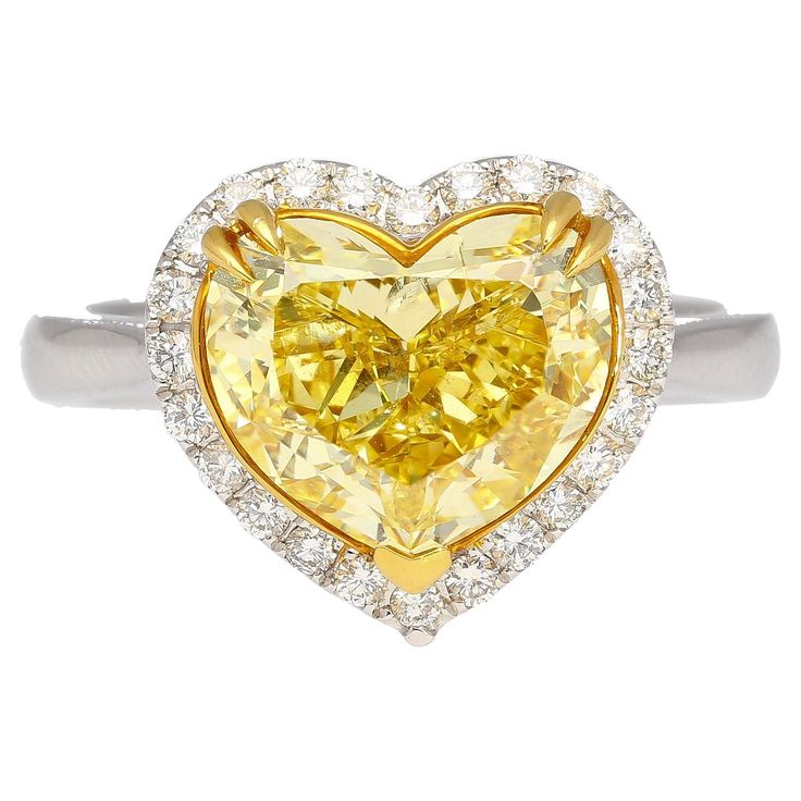 a heart shaped yellow diamond ring with diamonds around it