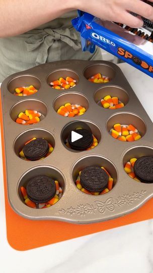 an orange tray filled with cupcakes and candy corn on top of a counter