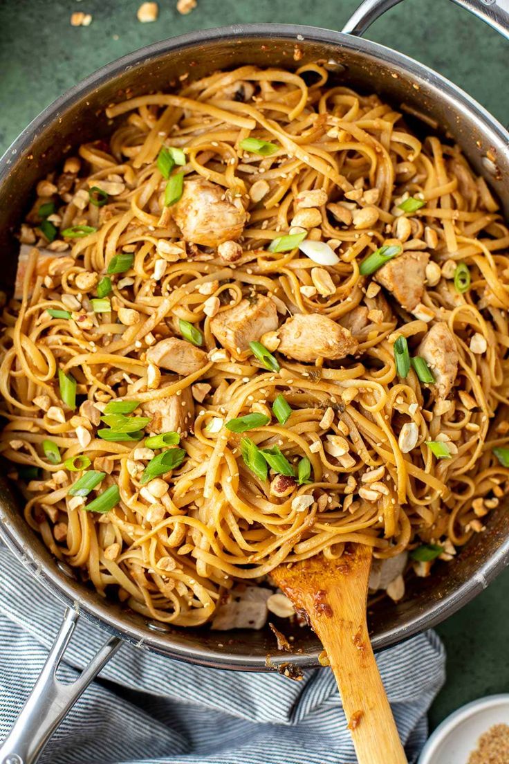 a pan filled with noodles and chicken on top of a table