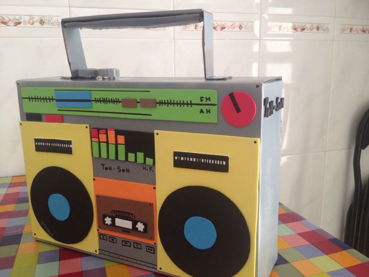 an old fashioned boom box with speakers on it sitting on a checkered table cloth