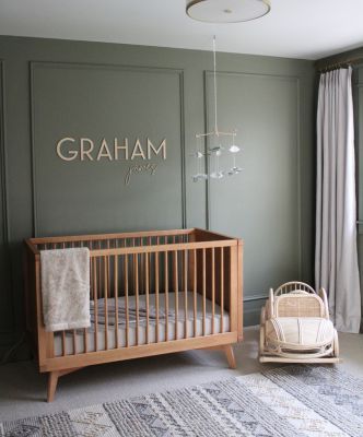 a baby's room with a crib, chair and rug