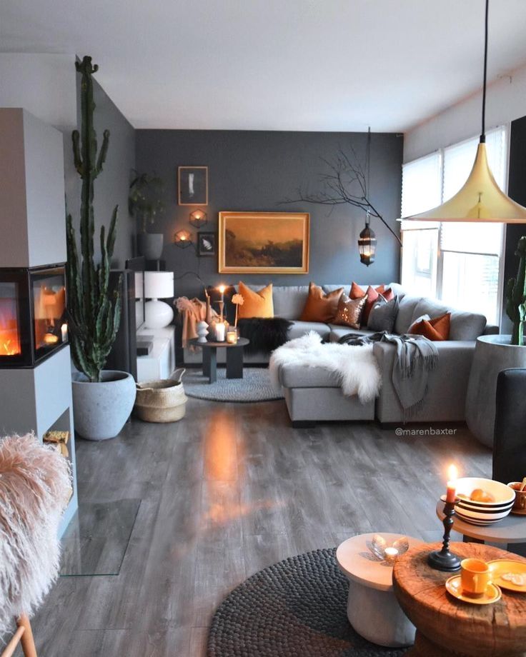 a living room filled with furniture and a fire place next to a couch on top of a hard wood floor