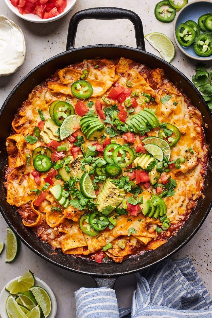 a skillet filled with tortilla shells and topped with guacamole