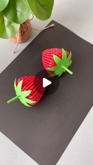 two strawberries are sitting on a black surface