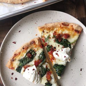 two slices of pizza sitting on top of a white plate