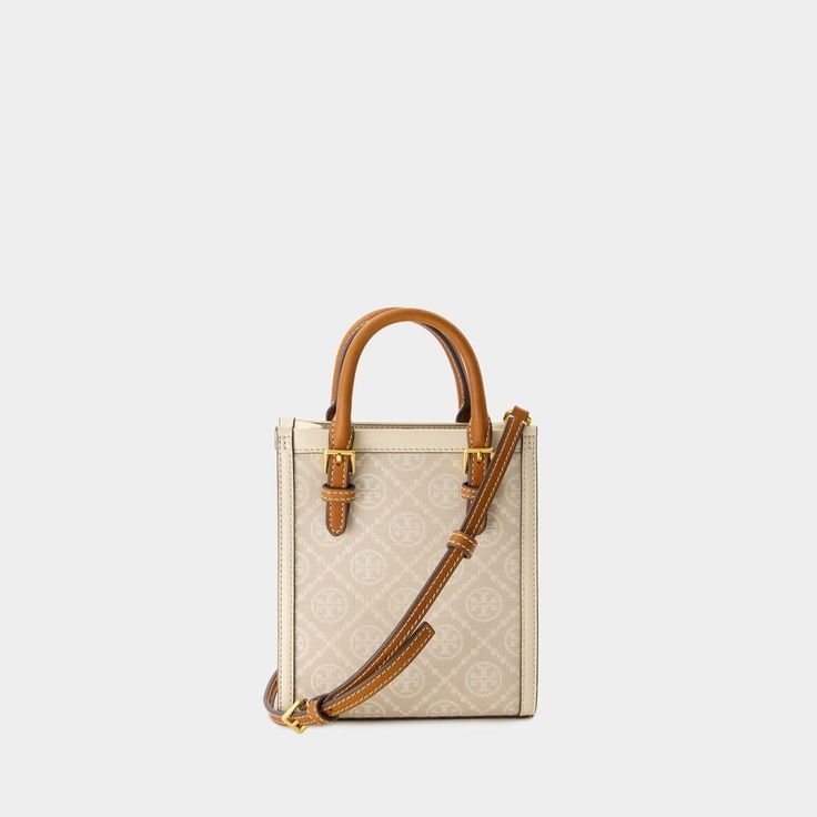 This Tory Burch mini shopper bag features a chic monogram fabric design complemented by two tan leather handles and an adjustable shoulder strap. The interior, lined with microfiber, includes an internal card compartment and a magnetic closure for convenient access.

- Monogram fabric design
- Tan leather handles
- Adjustable shoulder strap
- Microfiber-lined interior
- Internal card compartment
- Magnetic closure T Monogram, Canvas Leather Tote, Pennsylvania Dutch, Monogram Tote Bags, Monogram Handbag, Womens Designer Handbags, Barrel Bag, Monogram Tote, Mini Tote Bag