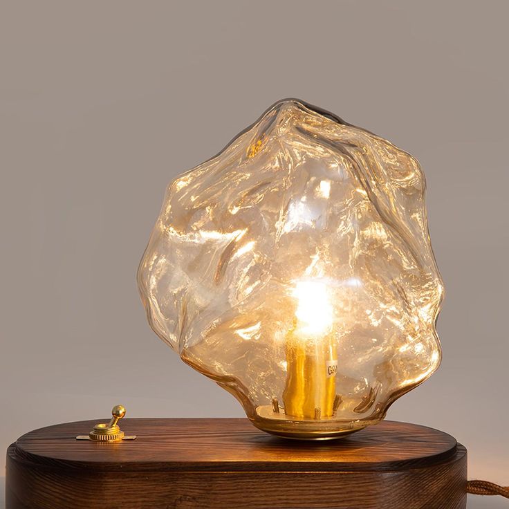 a light that is sitting on top of a wooden table next to a small candle