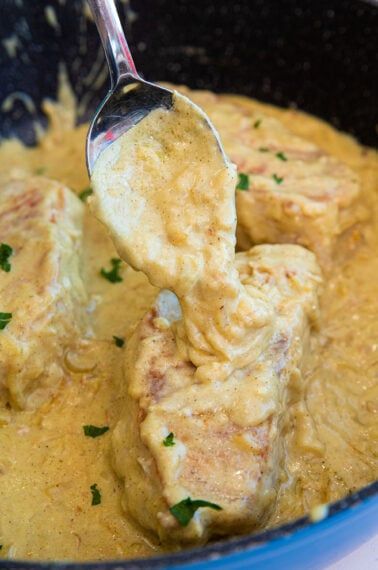 a close up of food in a bowl with a spoon sticking out of the meat