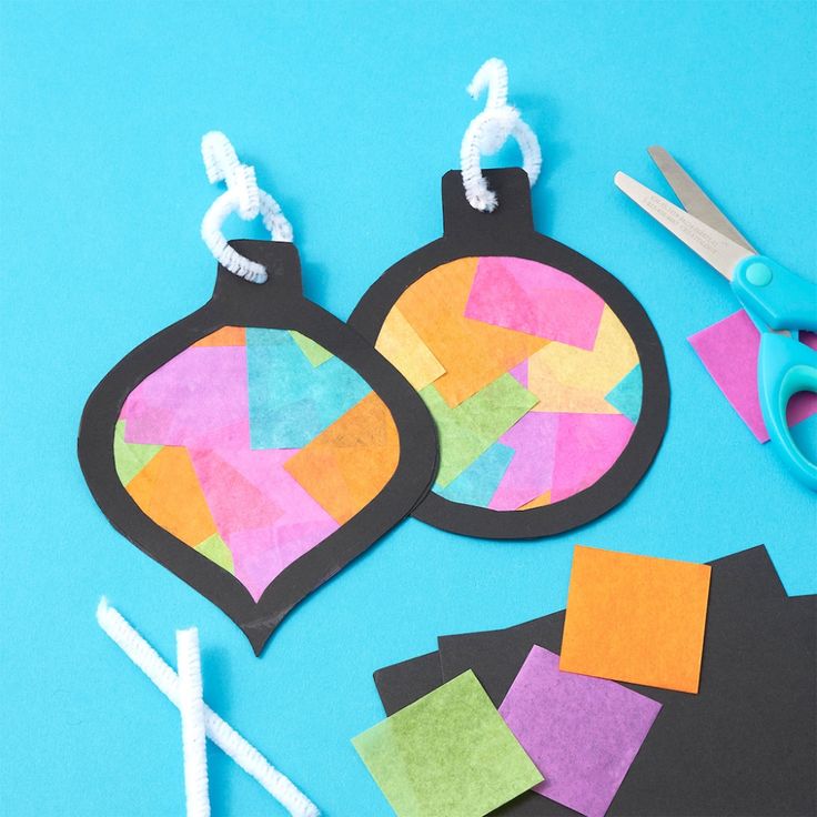 some crafting supplies are laid out on a blue surface with scissors and paper pieces