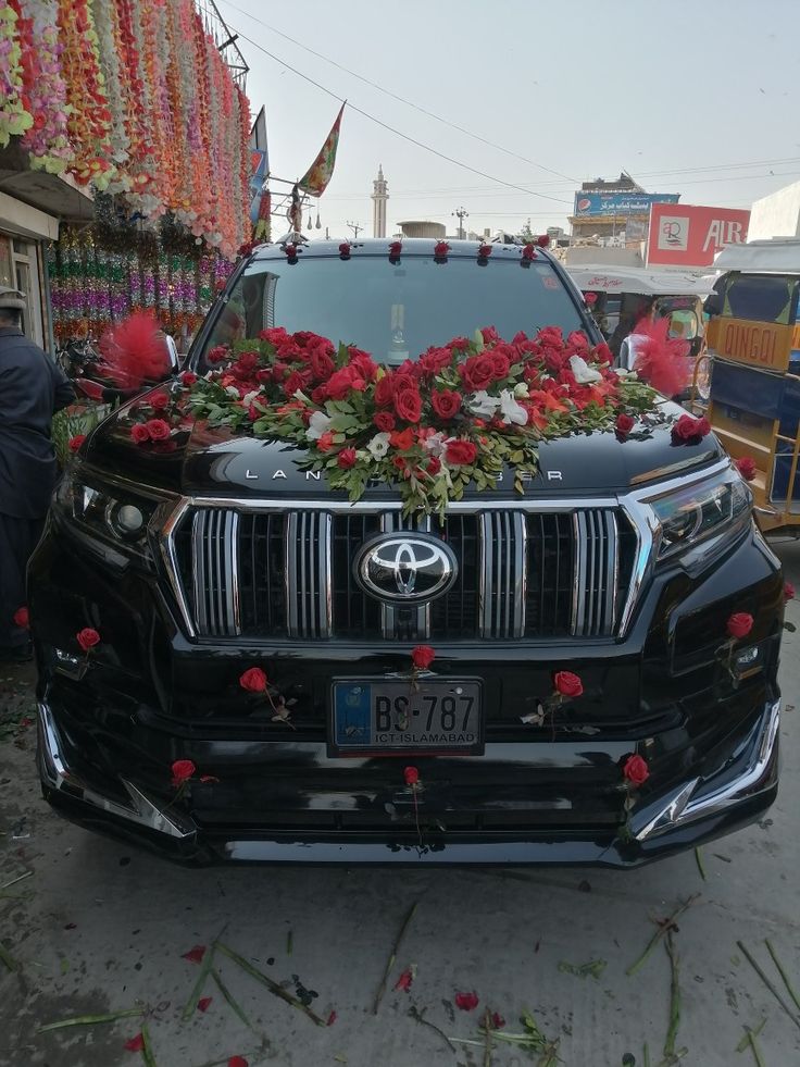 the front end of a black toyota suv decorated with flowers