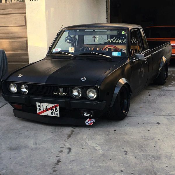 a black car parked in front of a garage