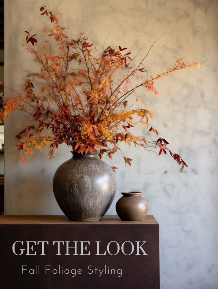 a vase filled with flowers sitting on top of a wooden table next to a sign that says get the look fall foliage