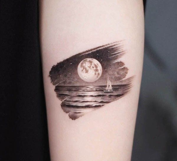 a tattoo with the image of a sailboat on it's side, under a full moon