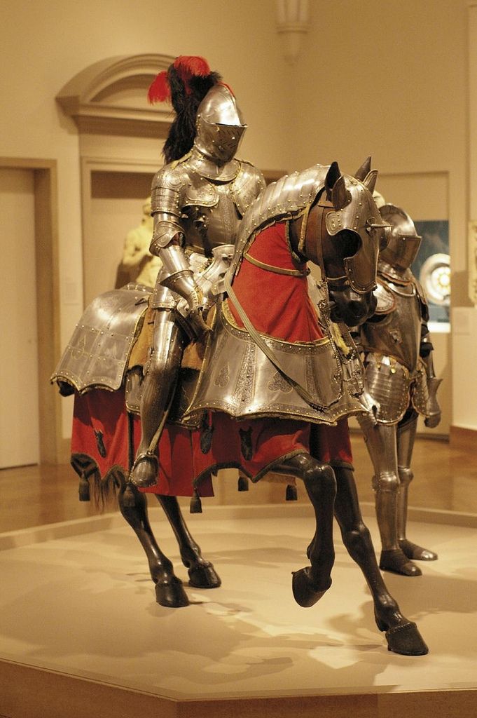 a couple of knights on horses in a museum