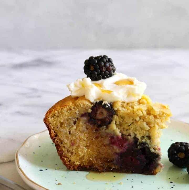 a piece of cake on a plate with blackberries