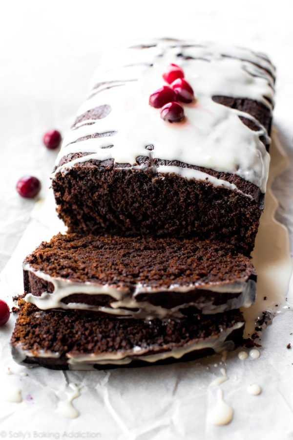 a chocolate cake with white frosting and cherries on top, cut in half