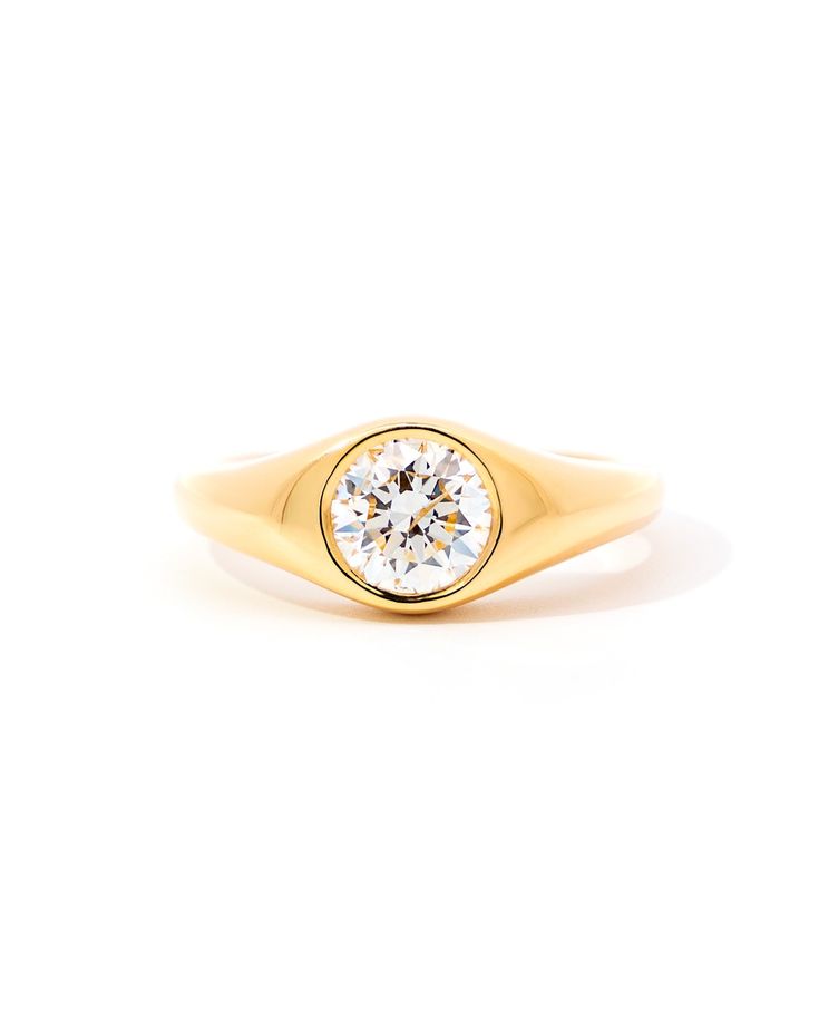 a yellow gold ring with a round diamond in the center