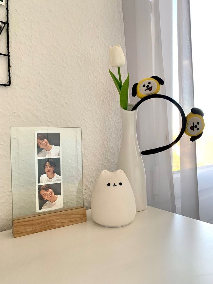 a white vase with flowers in it sitting on a table next to a polar bear