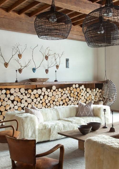 a living room filled with furniture and lots of wood slices on the wall behind it