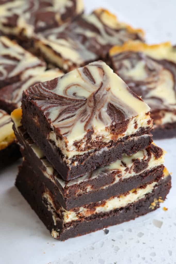 several pieces of brownie with white frosting on them sitting next to each other