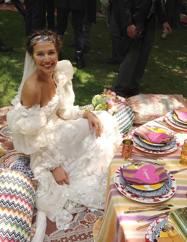 a woman sitting on top of a table covered in lots of plates and napkins