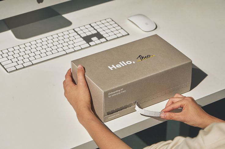 a person holding a knife in front of a box with the word hello on it