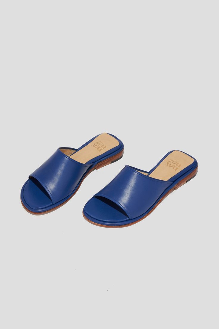 Get ready for the Pileta Slide in Cobalt to be your favorite summer shoe. It's got the ease of a flip-flop but is as finely crafted as any shoe in our collection, which means it's going to be a keeper. Its simple shape and stand-out color will make it easy to combine with a range of textures, fabrications and silhouettes in your summer wardrobe. Who it's for: The woman who loves a pop of color. Kidskin upper with vegetable tanned leather lining and a 25 mm stacked leather heel and sole. Handmade in Argentina. Blue Sandals With Rubber Sole For Vacation, Blue Open Toe Slippers With Removable Insole, Blue Summer Slippers With Rubber Sole, Summer Blue Slippers With Rubber Sole, Blue Beach Sandals With Leather Sole, Blue Sandals With Leather Sole For Beach, Blue Leather Sole Sandals For The Beach, Modern Blue Slip-on Sandals, Blue Textured Sole Sandals With Open Toe