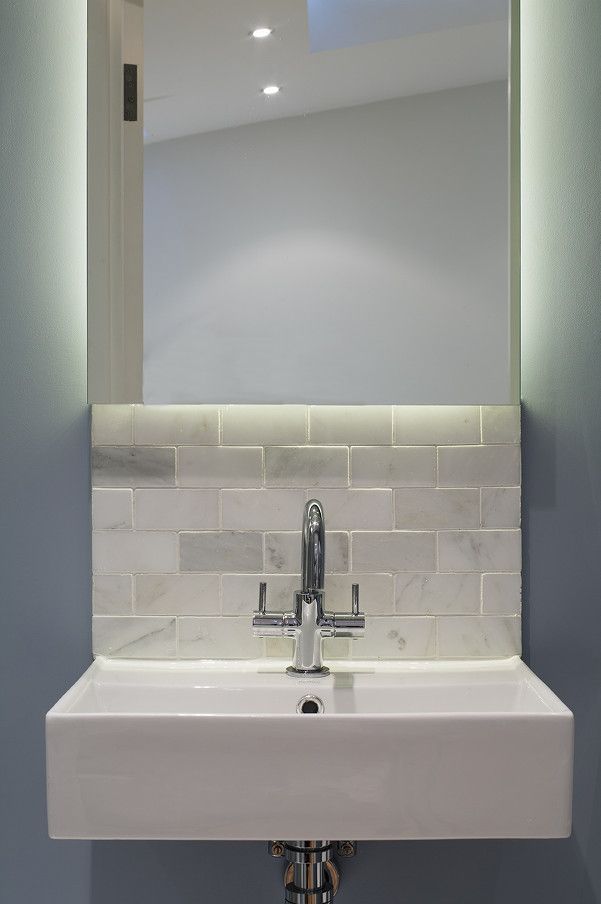 a bathroom sink under a large mirror in front of a wall mounted faucet