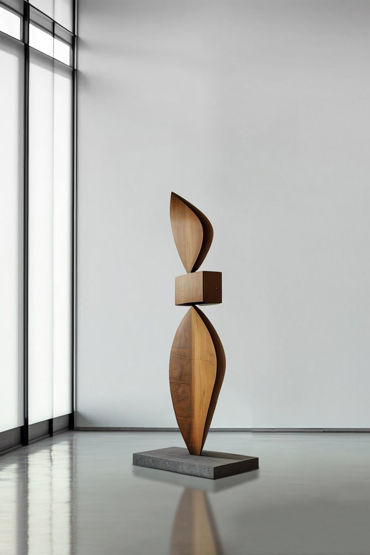 a wooden sculpture sitting on top of a white floor next to a tall glass window