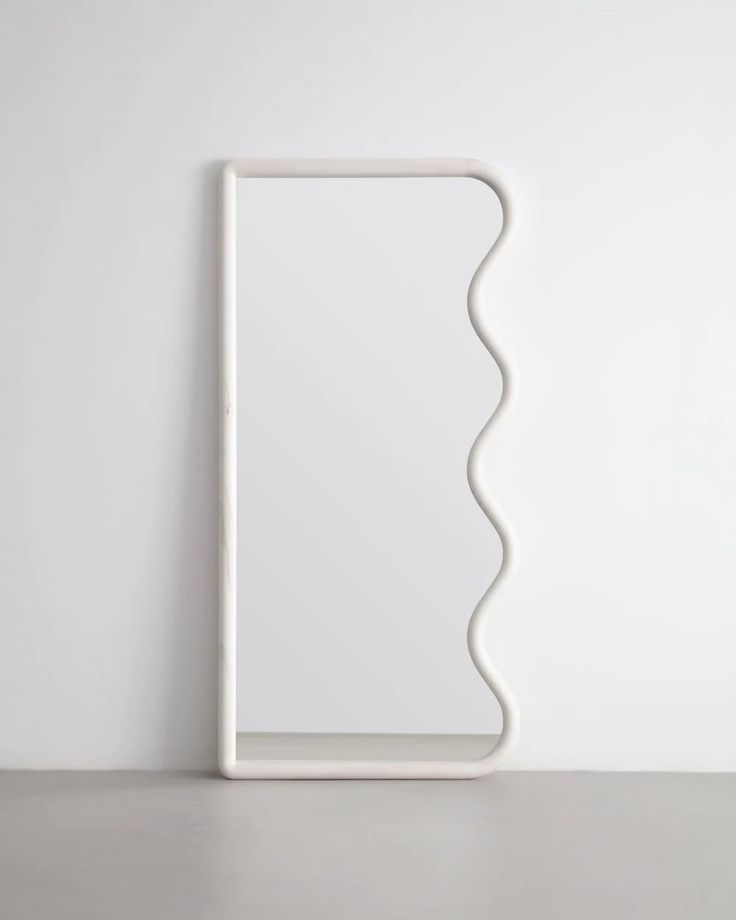 a white square shaped object sitting on top of a table next to a wall mounted mirror