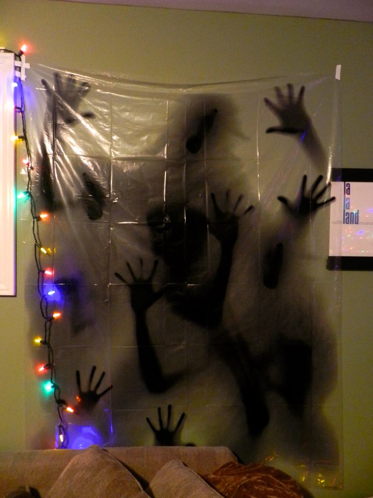 a bedroom decorated for halloween with hand prints on the wall and lights hanging from the ceiling