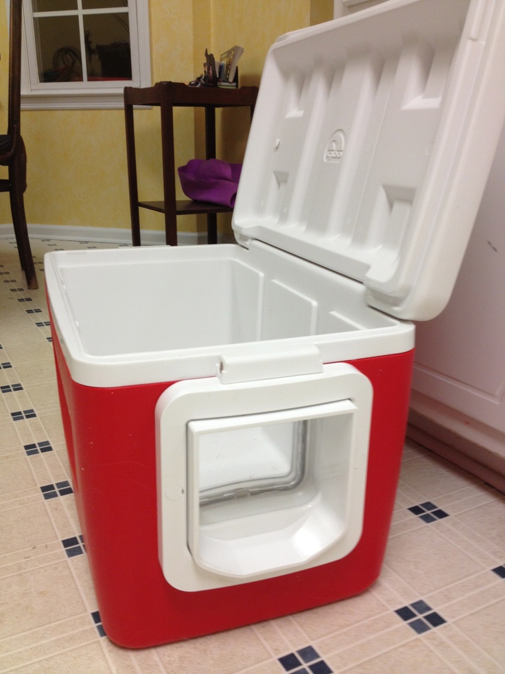 a red and white cooler sitting on top of a tiled floor next to a window