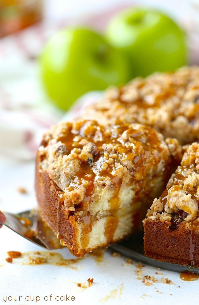 a close up of a cake on a plate with a fork next to it and an apple in the background